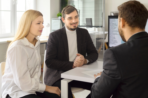 Casal reunido com gestor de crédito a analisar cenários de financiamento habitaçã